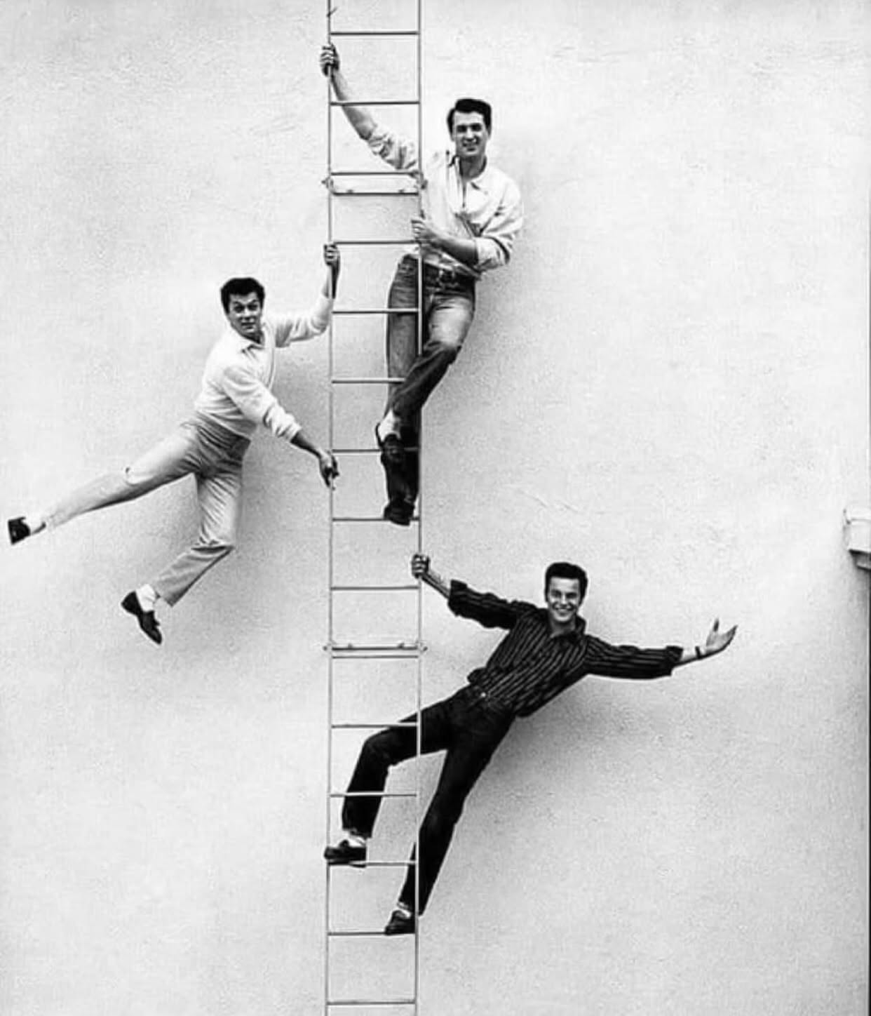 That summer of 1954, Life magazine ran a story about the “next generation” of leading men—those of us who were supposed to take the baton from Gable, Cooper, and Stewart. They called Rock Hudson, Tony Curtis, and me “The Big Three for Bobbysoxers.”
The photographer had the clever idea to put us on a ladder, each of us literally climbing to reach the next rung. It was meant to be symbolic—a friendly rivalry between three young actors trying to make their mark in Hollywood.
Looking back now, I remember that day fondly. We were all full of ambition, energy, and hope for what was ahead. None of us knew where our paths would lead, but we shared a love for the craft and a deep respect for those who came before us.
All these years later, that image still makes me smile. A moment frozen in time—three friends, chasing the dream.
#RobertWagner #RockHudson #TonyCurtis #LifeMagazine #HollywoodHistory #GoldenAgeOfHollywood #ClassicHollywood #OldHollywood #1950s #MovieLegends #HollywoodIcons #FilmHistory #BehindTheScenes #VintageHollywood #HollywoodStories #TheBigThreeForBobbysoxers #HollywoodDreams #JonathanHart #AnthonyDiNozoSr #HarttoHart #NCIS #MovieStar #TVStar  #ittakesathief #almundy #austinpowers #numbertwo